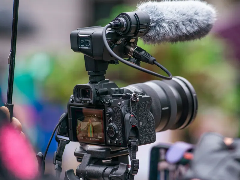 Mirrorless video camera with a furry shotgun microphone, videography equipment