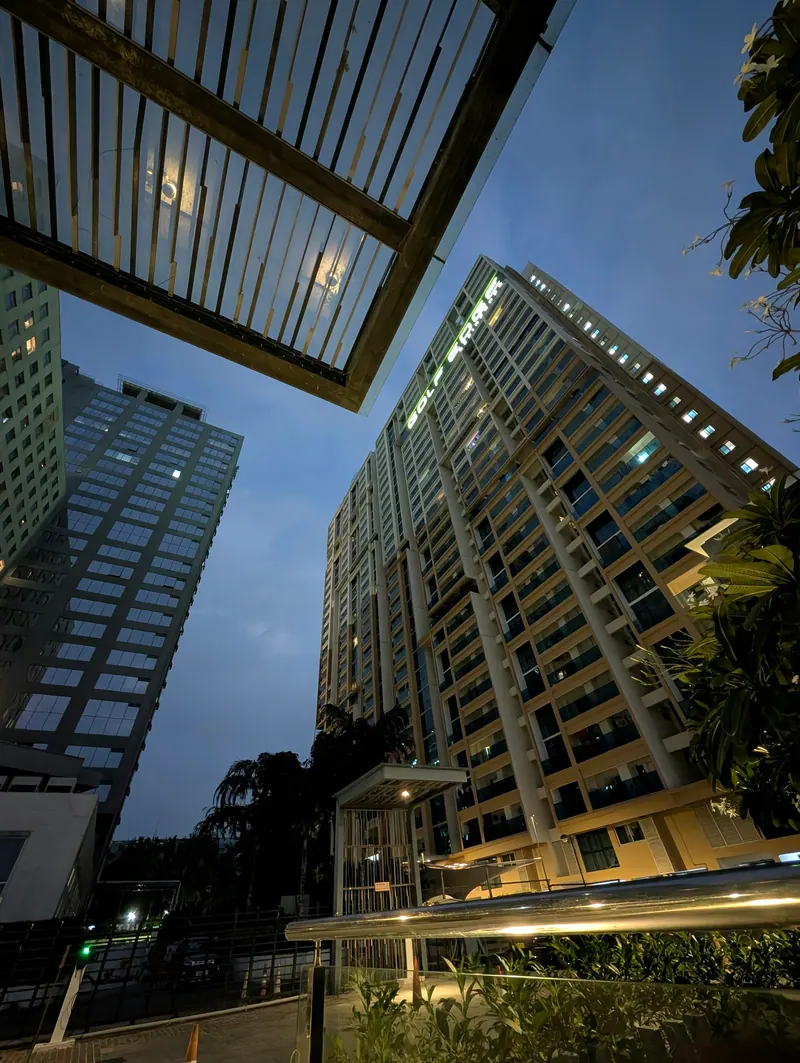 Residential towers at dusk with warm lit windows, real estate architecture photography