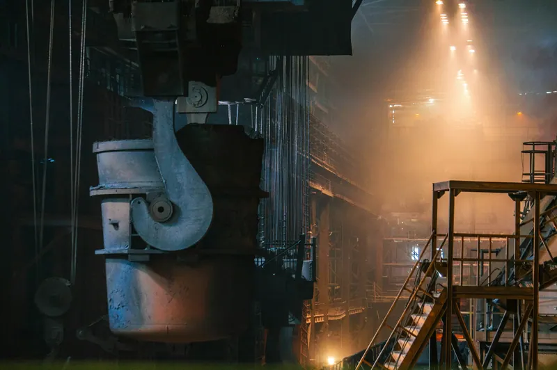 Steel plant interior with a molten metal ladle and warm industrial light, industrial videography
