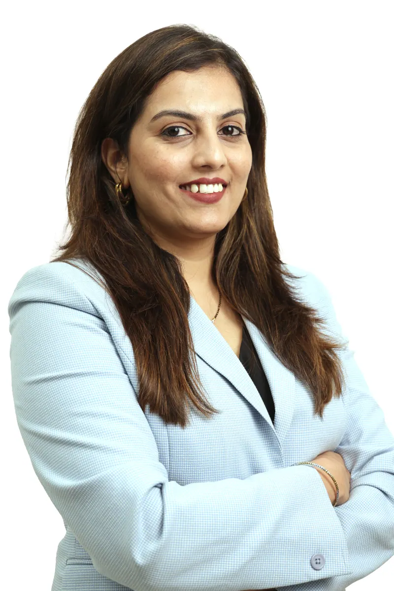 Businesswoman with arms crossed in a light blue blazer, confident corporate headshot against white