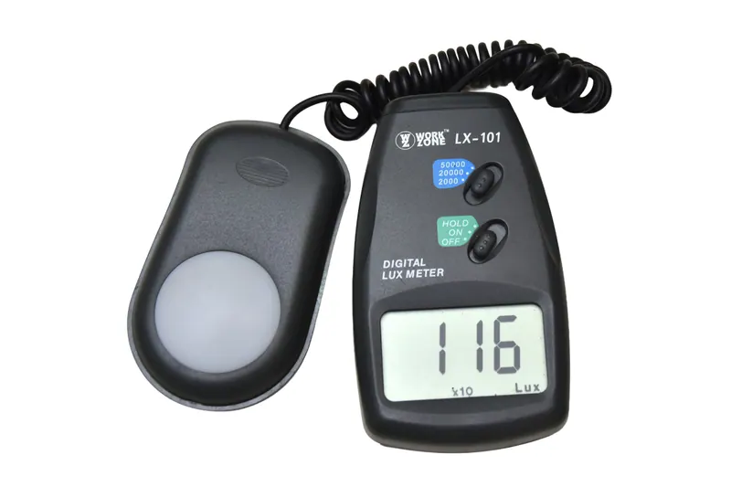 Digital lux meter with coiled sensor cable reading 116 lux on a white background, instrument product photography