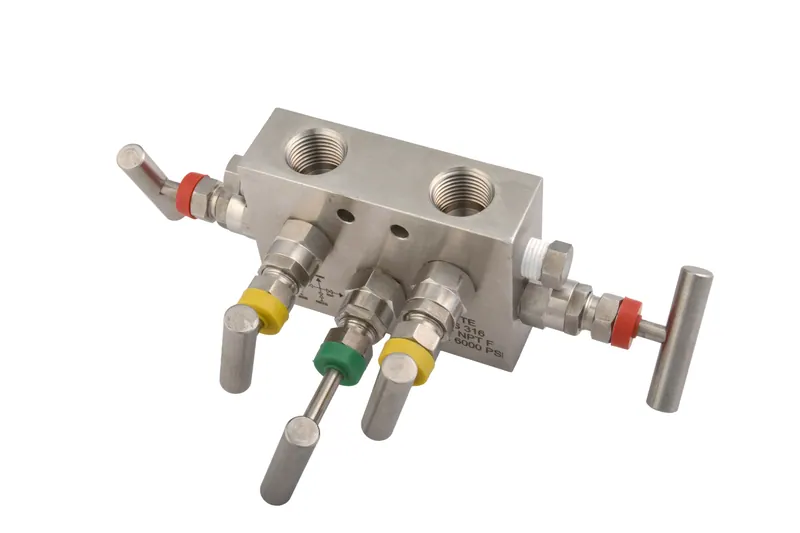 Angled view of a stainless steel five-valve manifold block showing machined ports and valve handles