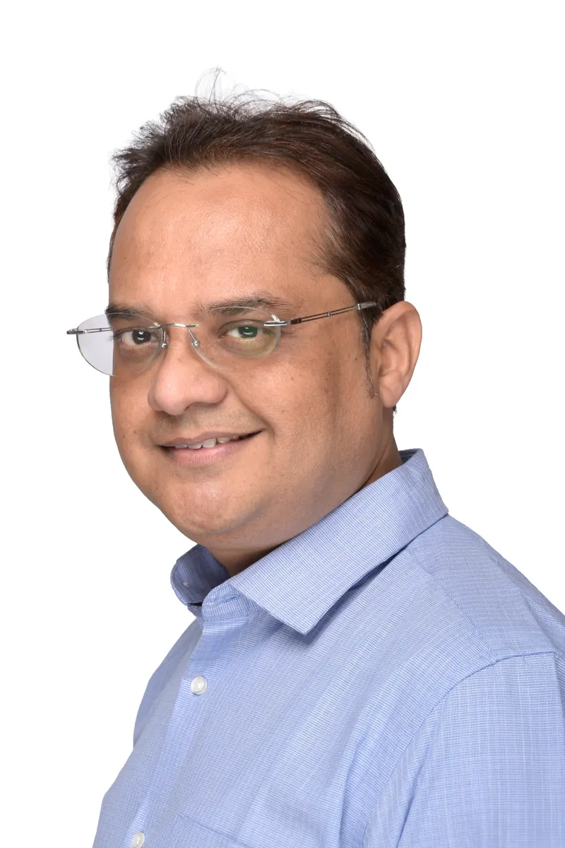Professional with rimless glasses in a light blue shirt, corporate team headshot