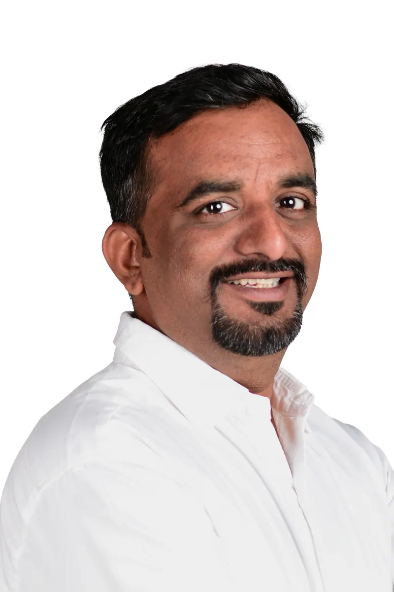 Smiling bearded manager in a white shirt, approachable corporate headshot on a white background