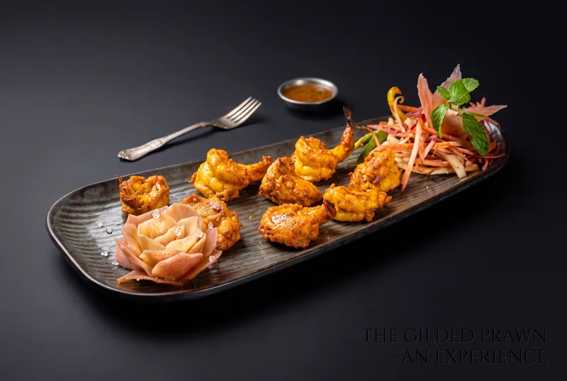 Tandoori prawns with a pink rose garnish and fresh salad on a dark plate, fine dining food photography in Pune