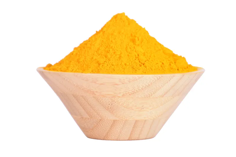 Bright yellow turmeric powder heaped in a pale wooden bowl on white, spice packaging and product photography