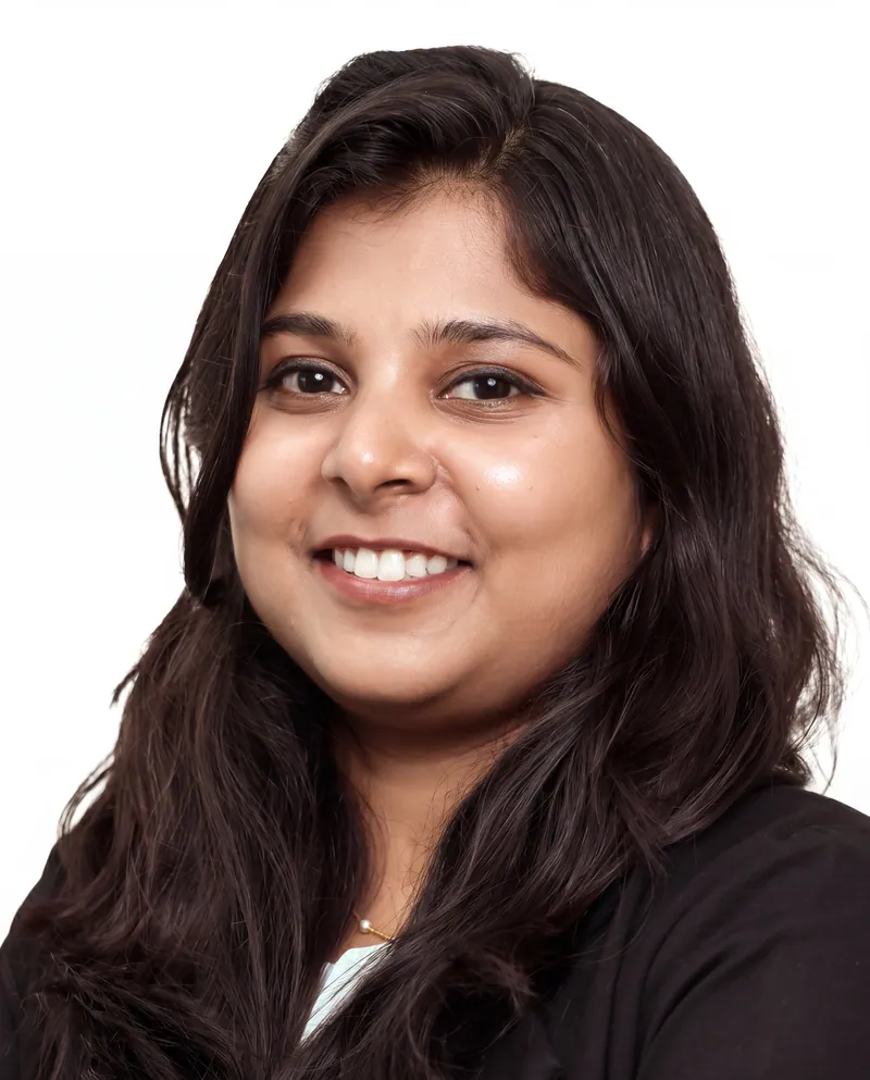 Smiling professional woman in a black blazer against a white backdrop, corporate headshot photography in Pune
