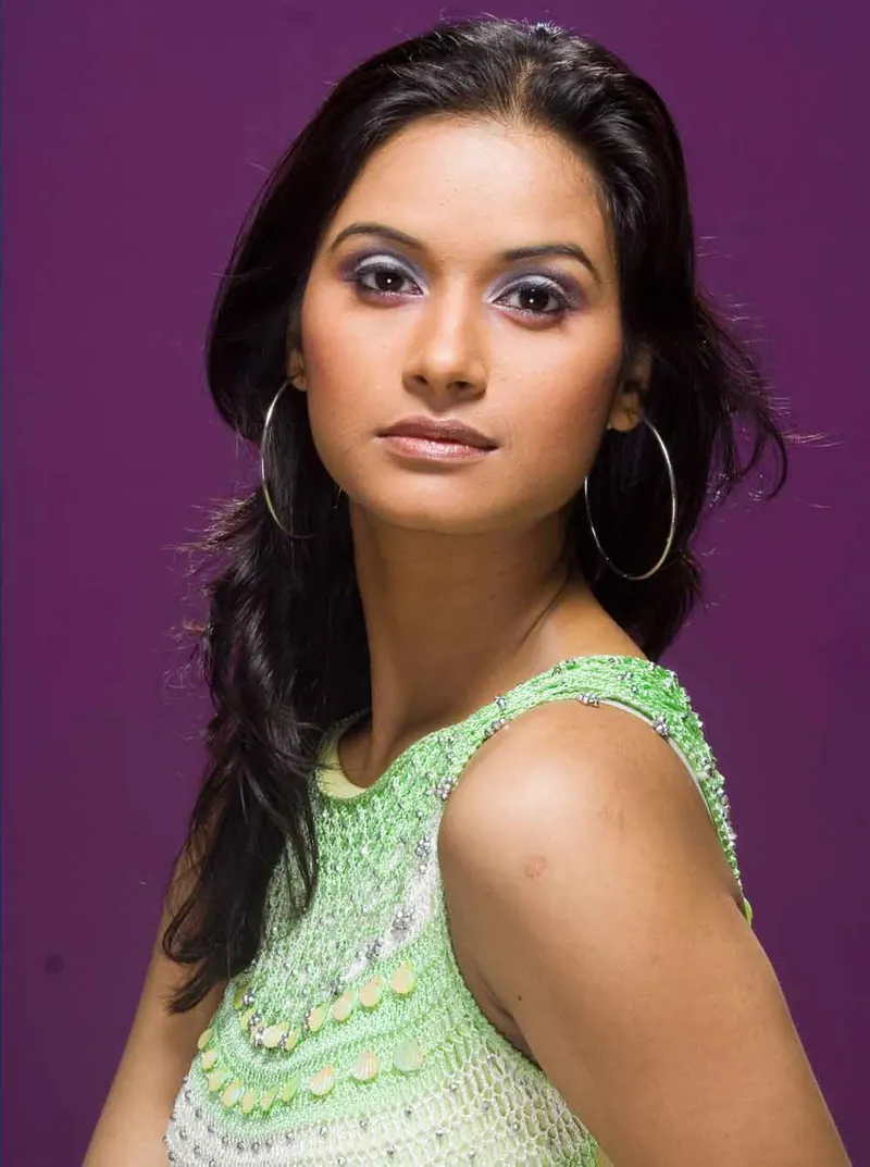 Woman in a green embellished top and hoop earrings against a purple backdrop, fashion portfolio photography in Pune